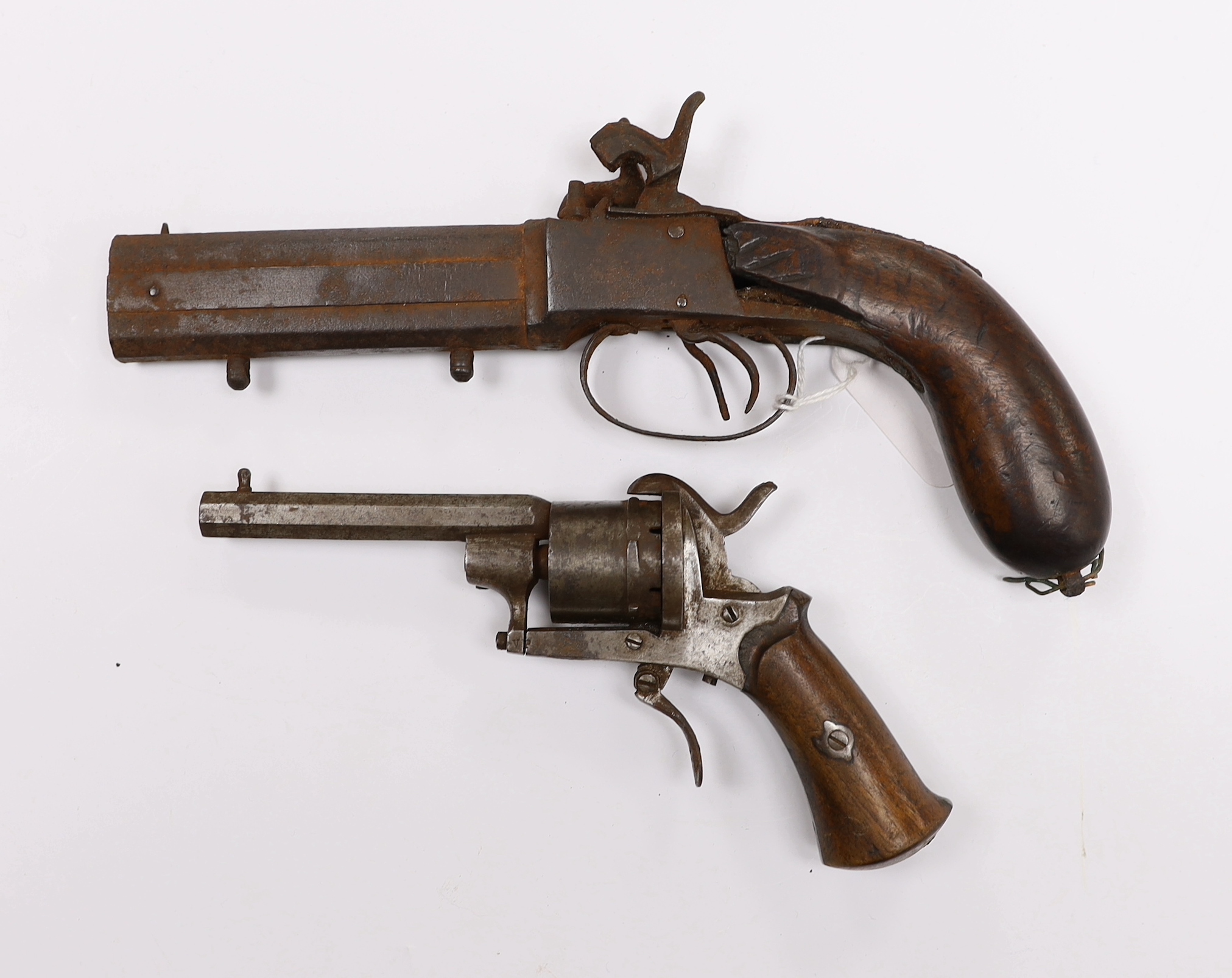 A 19th century six shot pinfire revolver with folding trigger, barrel 8cm, together with a relic over and under double barrelled percussion pistol, barrel 10cm (2)